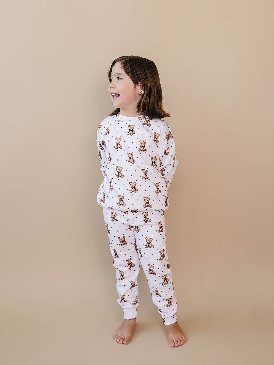 Side view of a child modeling the Cute Bear two-piece cotton outfit.
