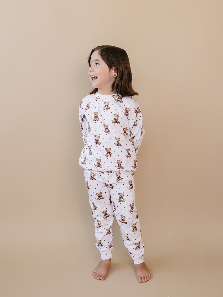 Side view of a child modeling the Cute Bear two-piece cotton outfit.
