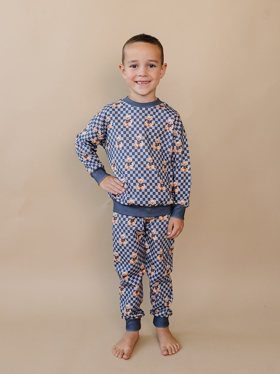 Child standing in the matching Checkered Bear Vibes long-sleeve top and jogger pants.