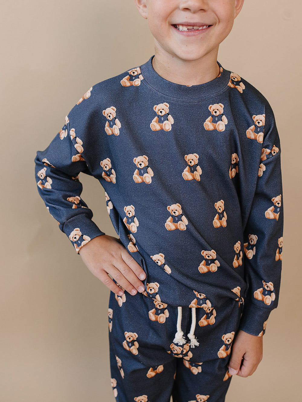 Close-up front view of a child wearing the Bear Vibes crewneck top and matching joggers.