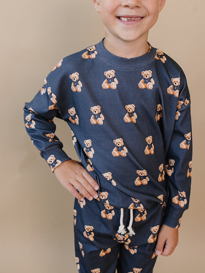 Close-up front view of a child wearing the Bear Vibes crewneck top and matching joggers.