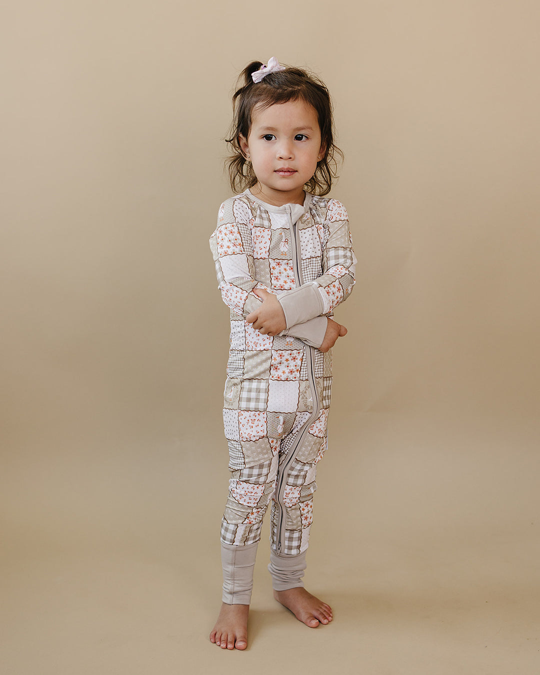 Toddler posing in the Cottage Goose bamboo zip romper in a full-body three-quarter studio view.