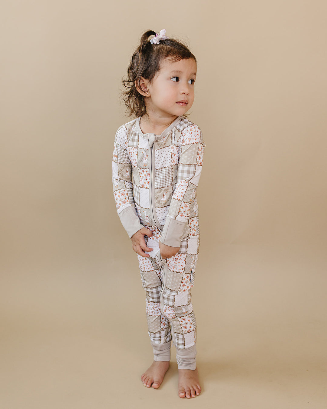 Toddler standing at a slight angle in the Cottage Goose bamboo zip romper, showing the full front fit.