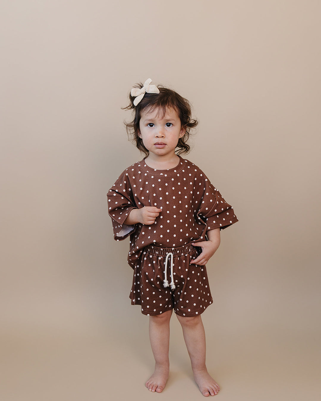 Toddler girl wearing Lucky Panda Kids Brown Polka Shorts Set — brown and white polka dot cotton two-piece outfit