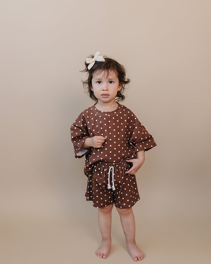 Toddler girl wearing Lucky Panda Kids Brown Polka Shorts Set — brown and white polka dot cotton two-piece outfit