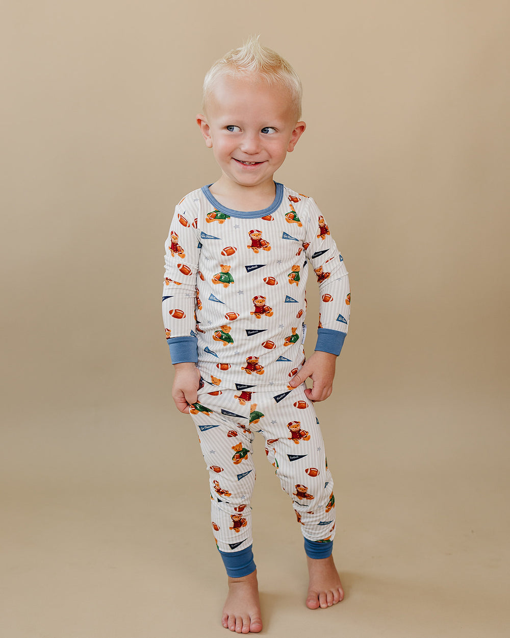 Full-length view of a toddler modeling the Touchdown Teddy bamboo top and matching pants.