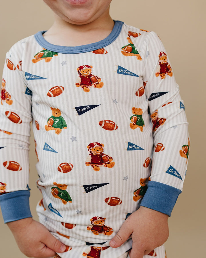 Close-up of a child wearing the Touchdown Teddy bamboo two-piece set with football and teddy bear print.