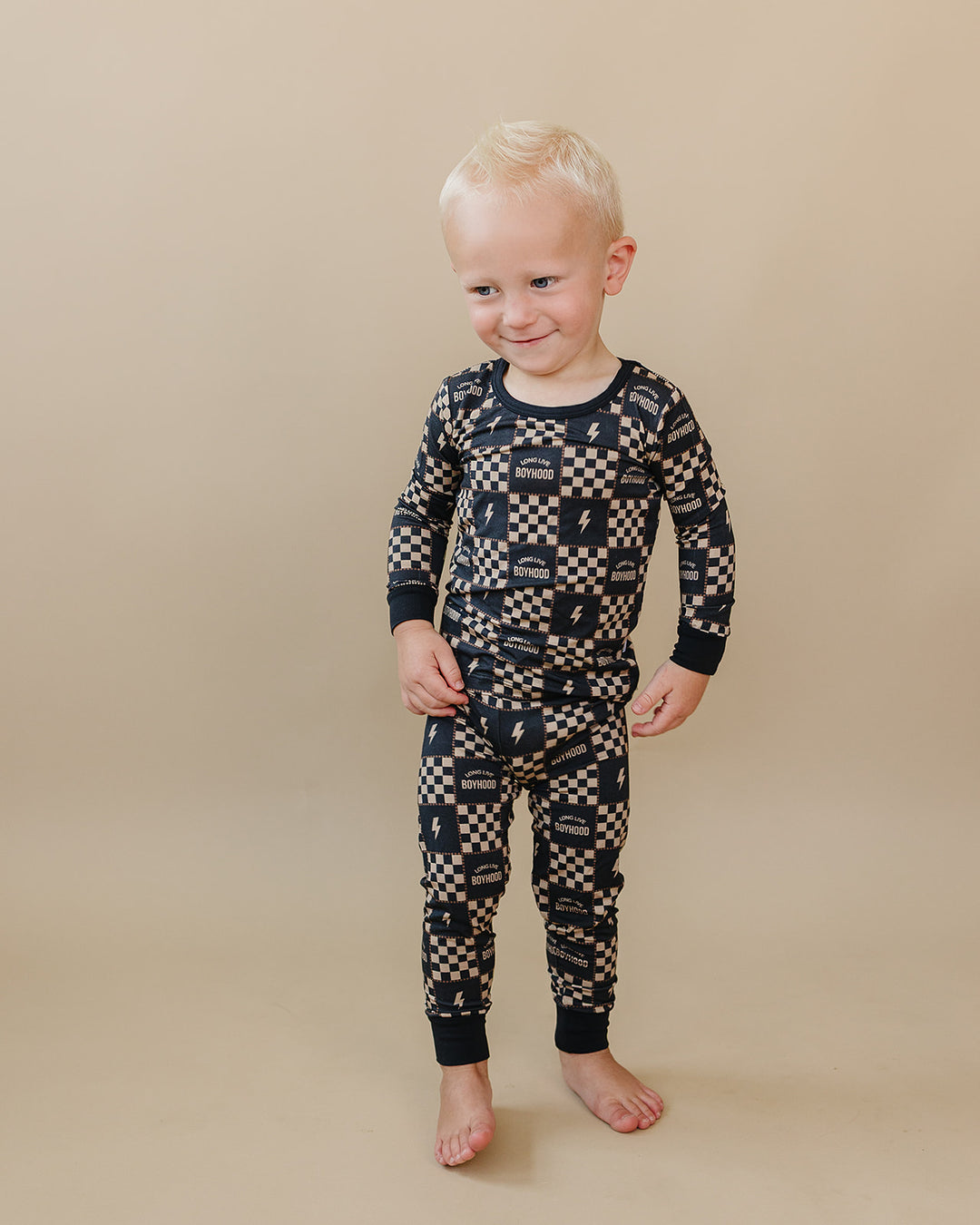 Toddler looking down while wearing the Long Live Boyhood checkered bamboo top and pants.