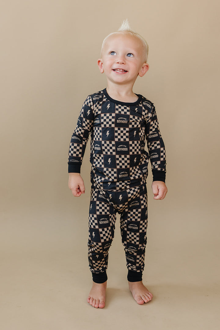 Front view of a toddler wearing the Long Live Boyhood long-sleeve bamboo pajama set.