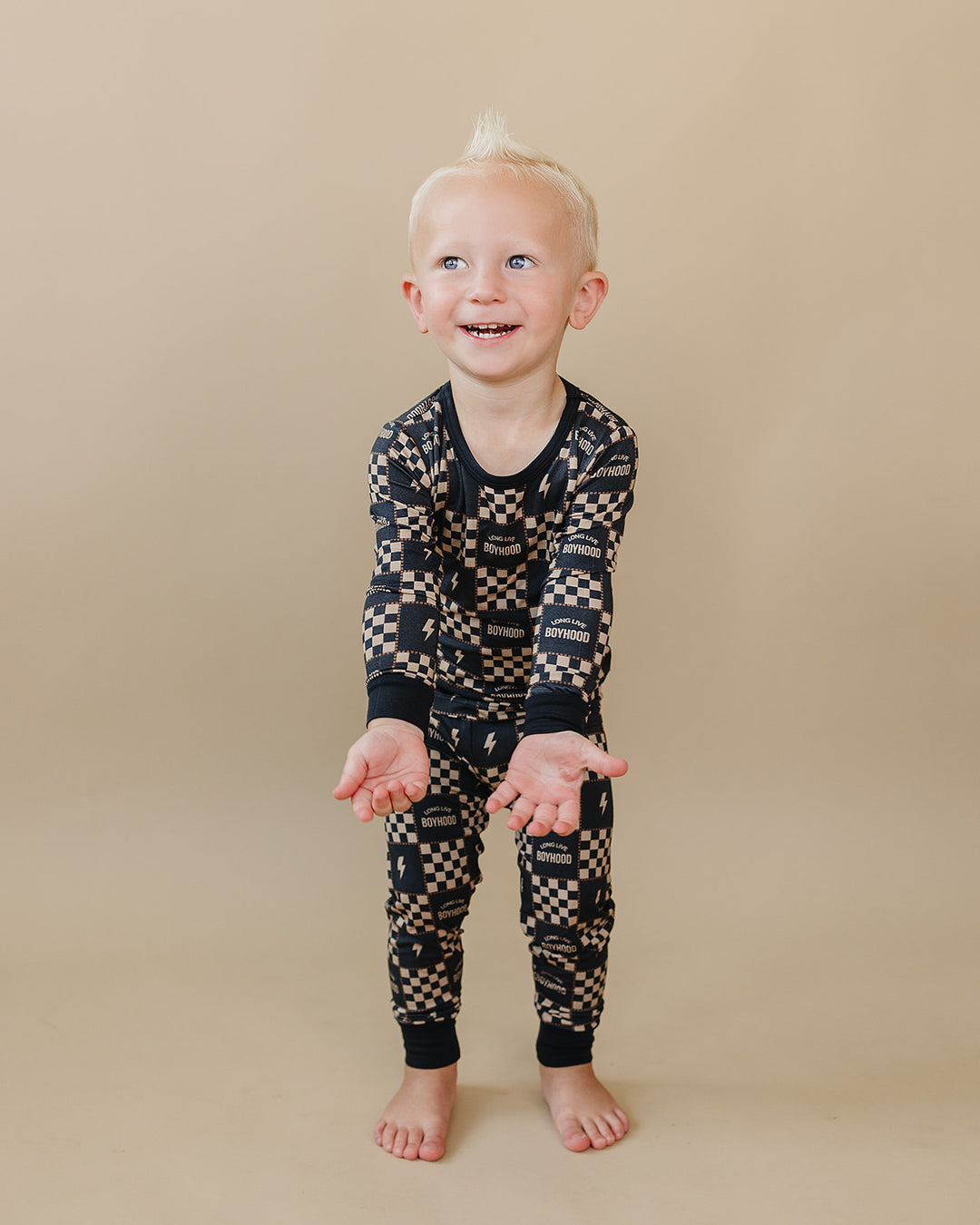 Toddler leaning forward with hands out in the Long Live Boyhood bamboo top and matching pants.