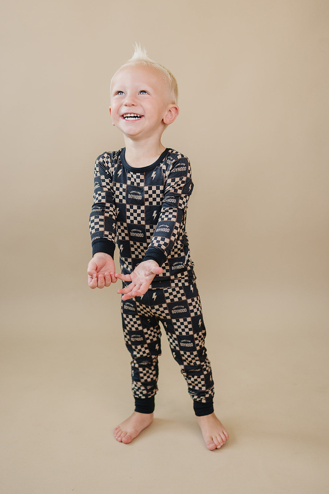 Laughing toddler wearing the Long Live Boyhood checkered bamboo top and matching pants.