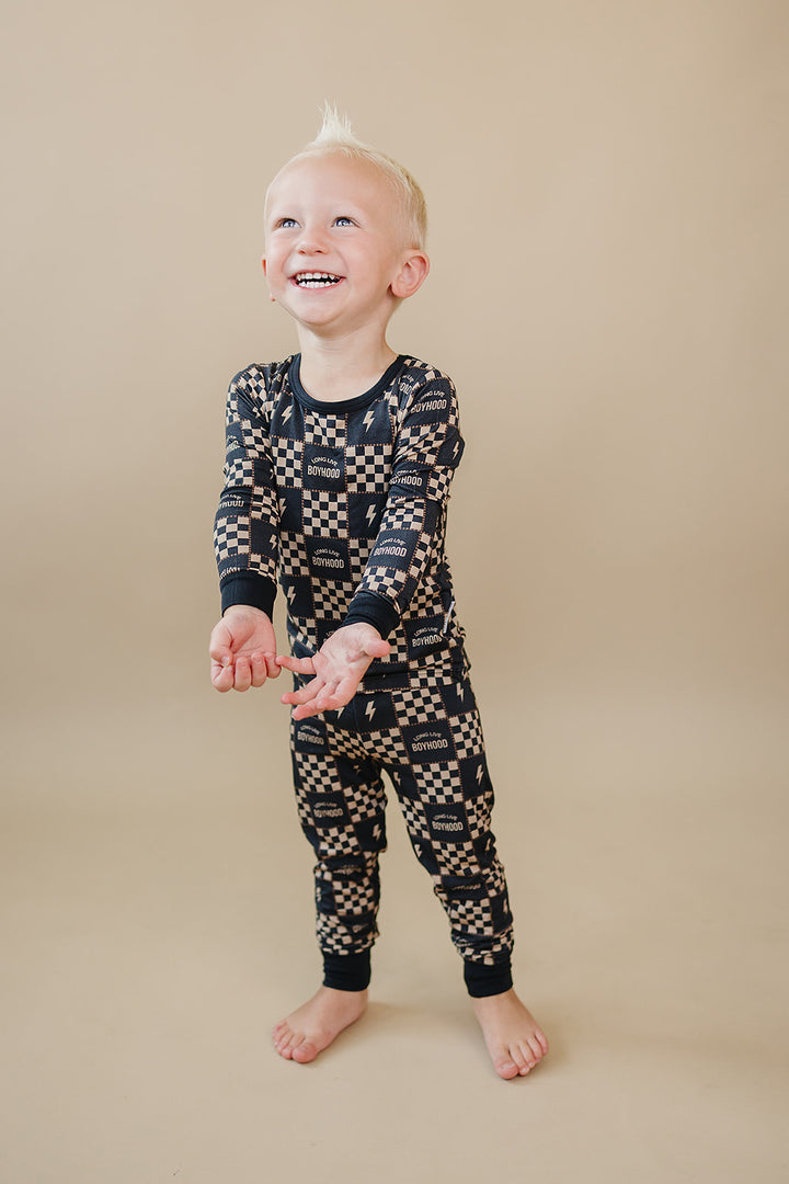 Laughing toddler wearing the Long Live Boyhood checkered bamboo top and matching pants.