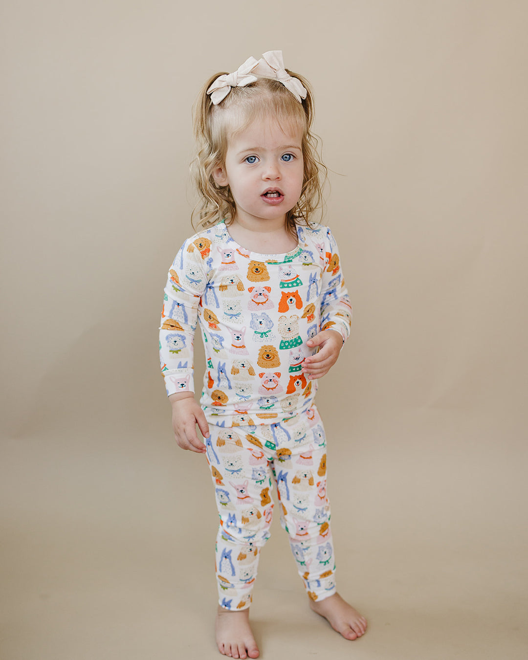 Toddler stepping forward in the Puppy Club bamboo long-sleeve top and matching pants with colorful puppy illustrations.