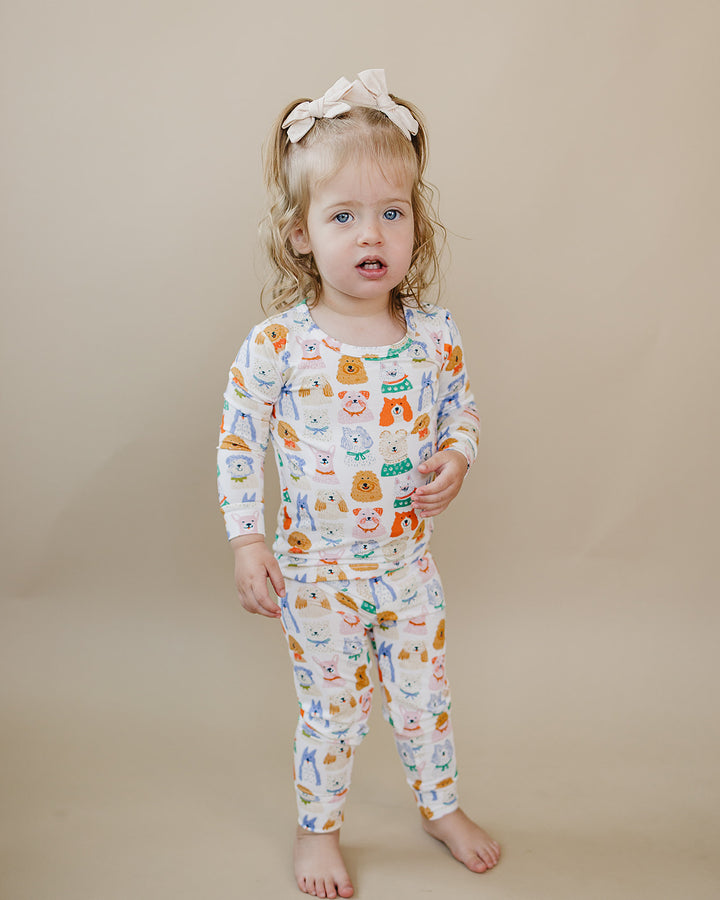 Toddler stepping forward in the Puppy Club bamboo long-sleeve top and matching pants with colorful puppy illustrations.