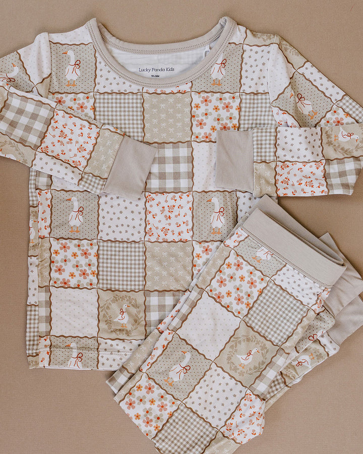 Cottage Goose bamboo long-sleeve top and matching pants laid flat, showing the complete neutral patchwork print.