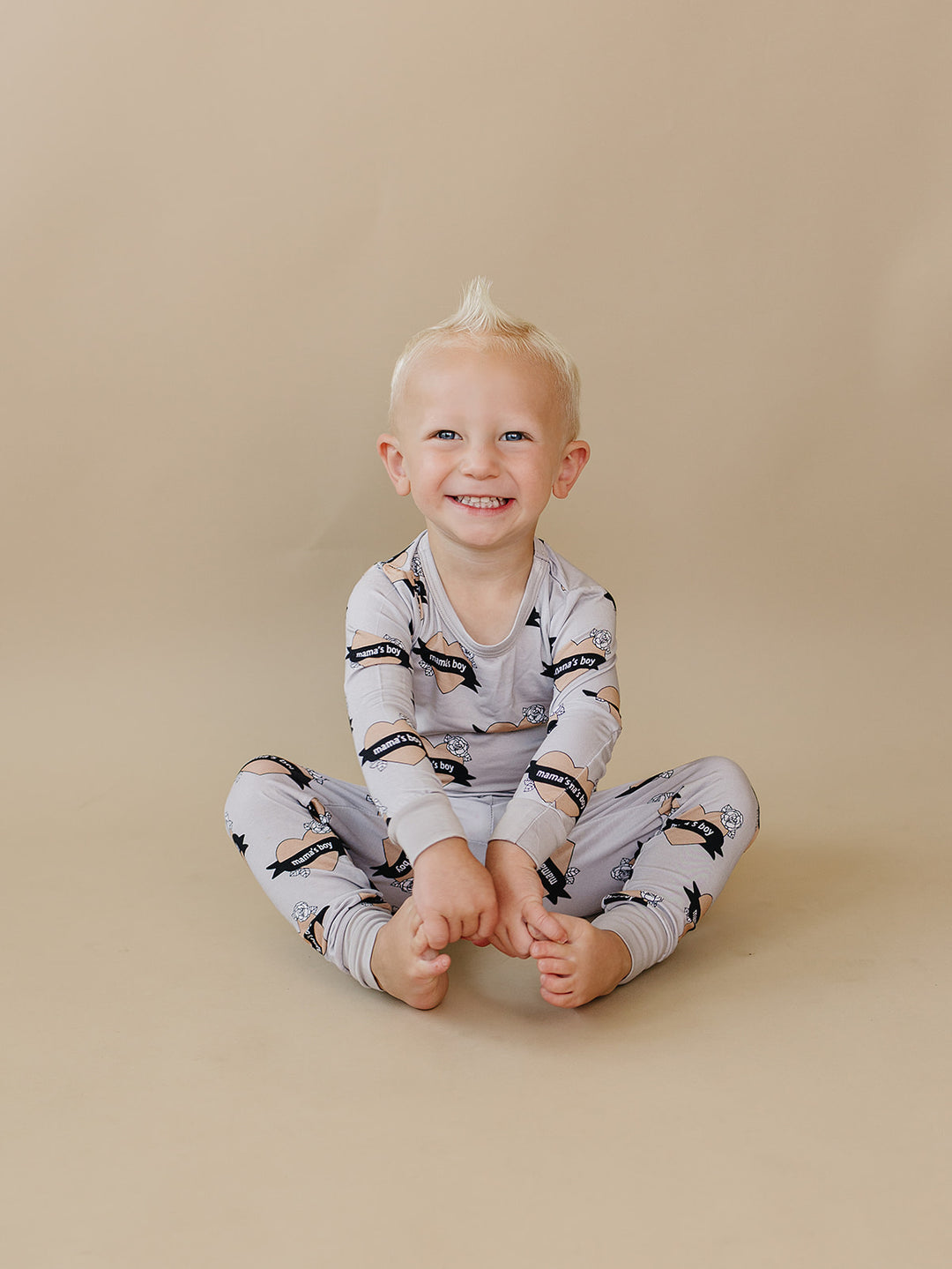 Toddler sitting cross-legged in the Mama’s Boy bamboo two-piece set.