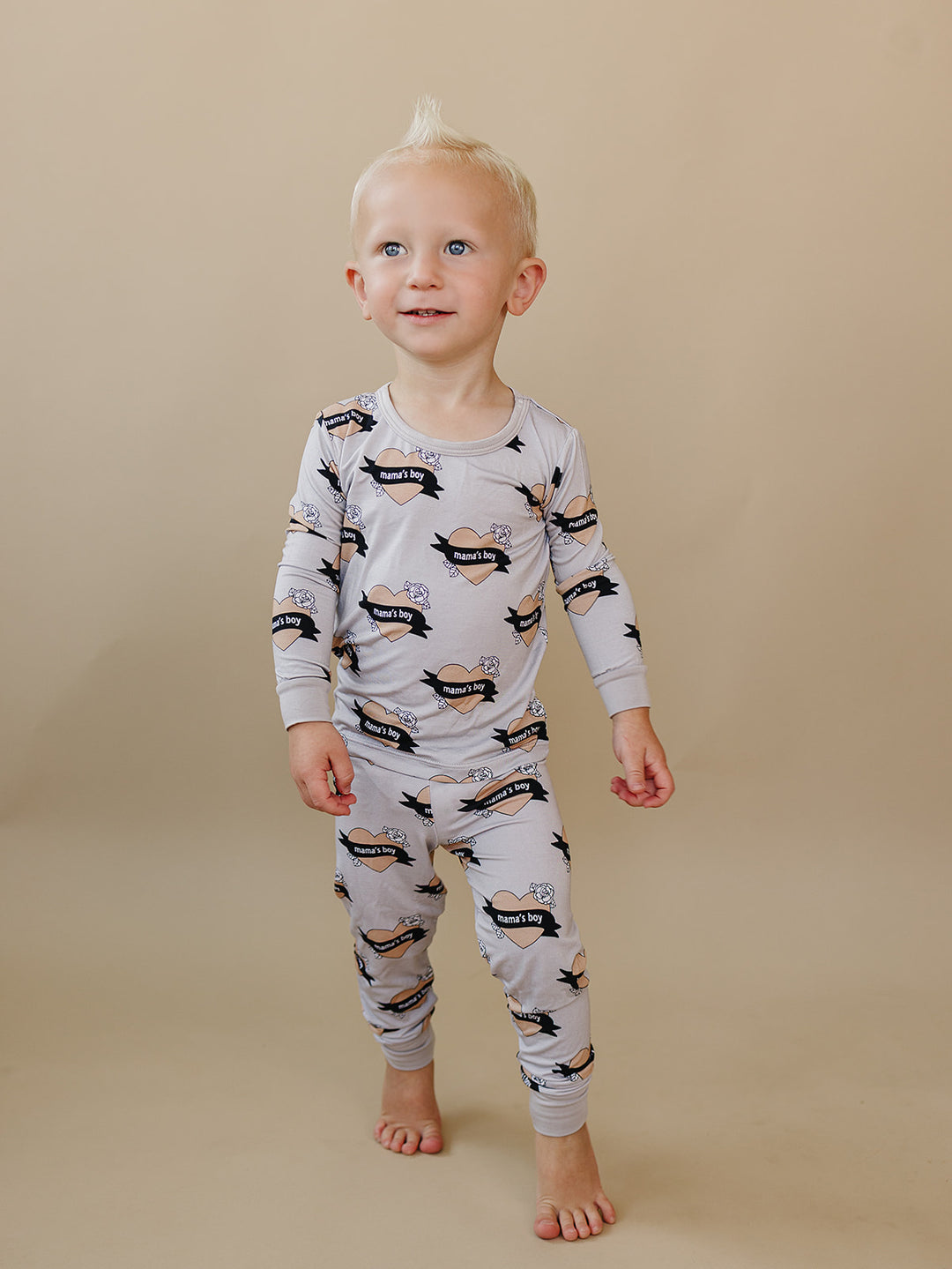Toddler looking to the side while wearing the Mama’s Boy heart-print bamboo top and pants.