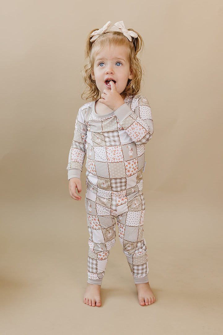 Smiling toddler walking forward in the Cottage Goose bamboo two-piece set.