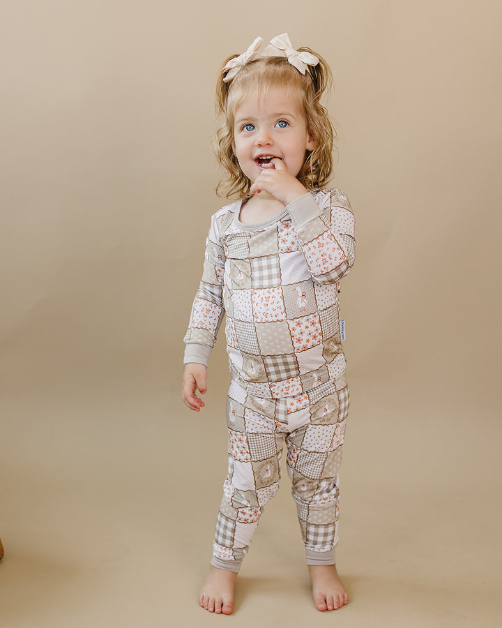 Toddler posing in the Cottage Goose bamboo two-piece set against a neutral beige studio background.