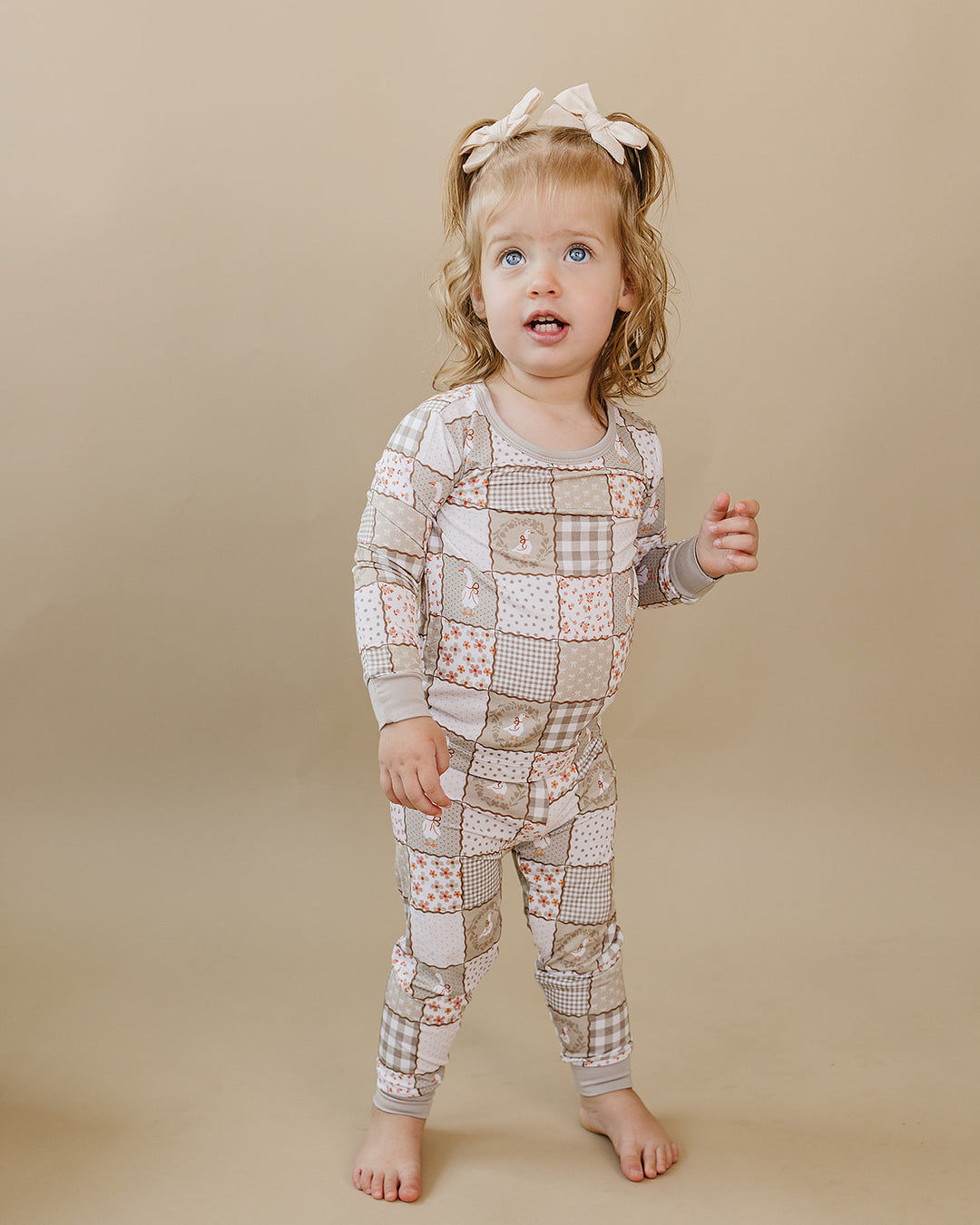 Toddler turning slightly while modeling the Cottage Goose bamboo two-piece set in a full-body view.