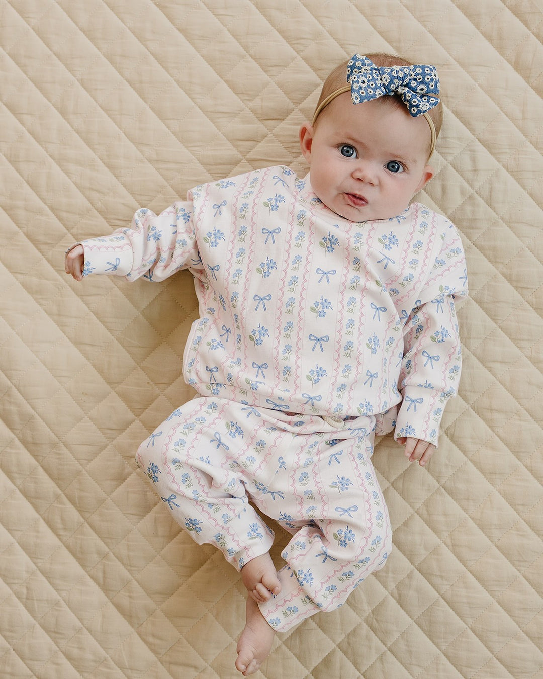 Baby wearing the Mama’s Boy bamboo zip romper seated with a toddler in the matching cotton jogger set.