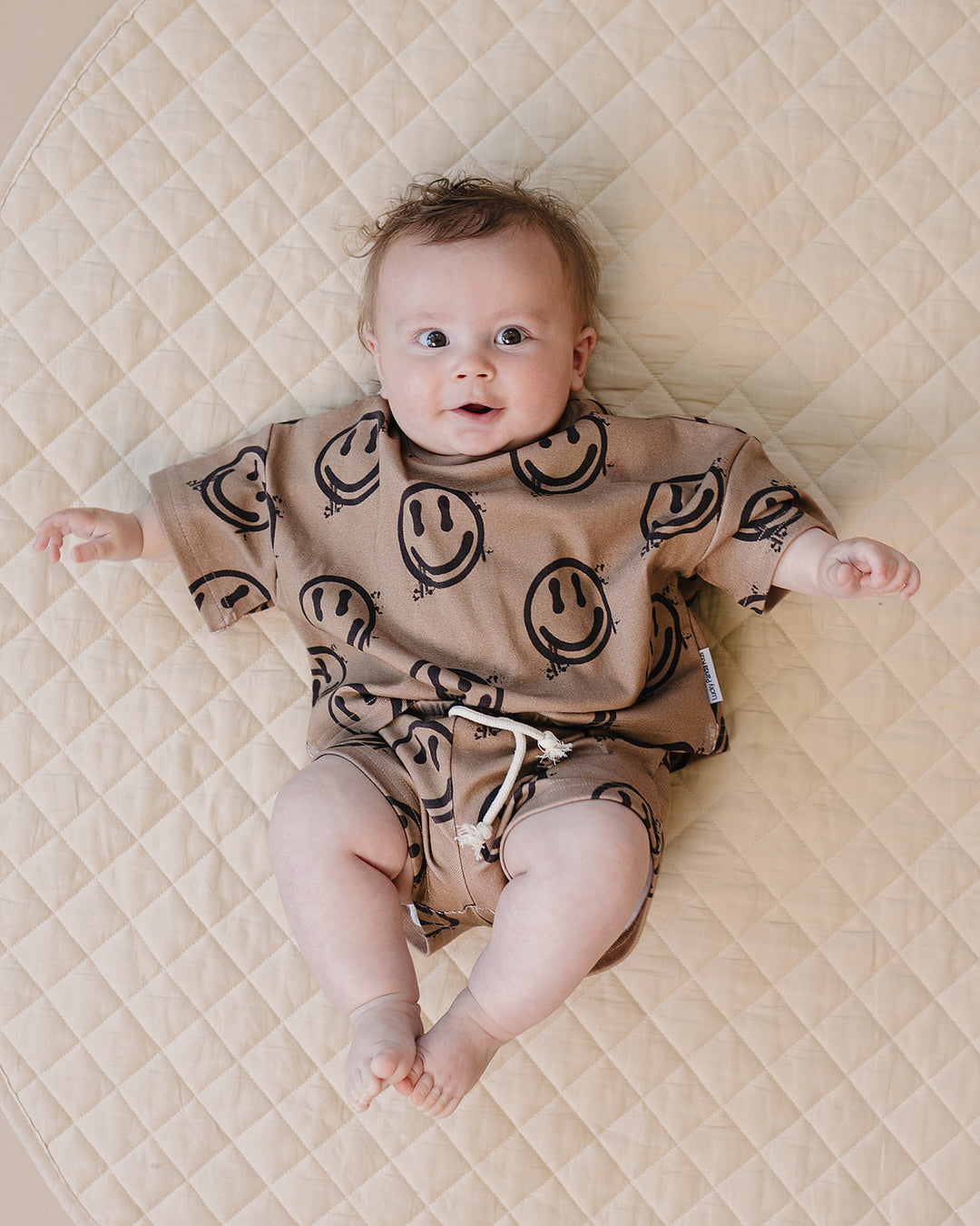 baby boy wearing Lucky Panda Kids Smiley Brown Shorts Set — warm brown all-over smiley face print cotton two-piece outfit