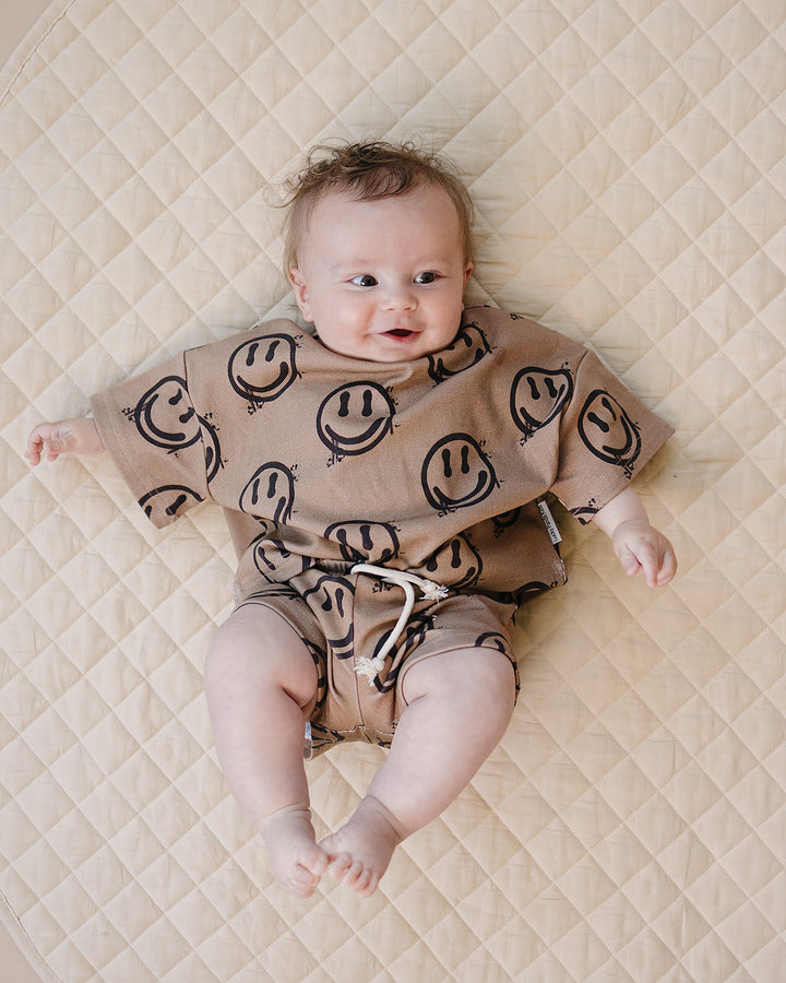 baby boy wearing Lucky Panda Kids Smiley Brown Shorts Set — warm brown all-over smiley face print cotton two-piece outfit