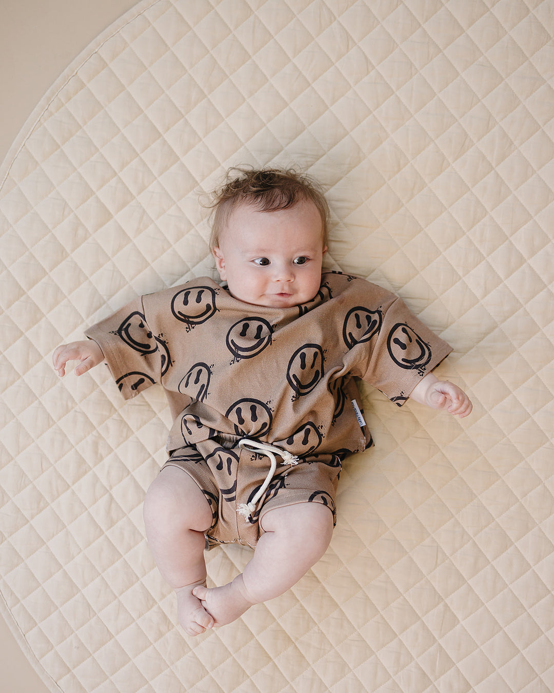baby boy wearing Lucky Panda Kids Smiley Brown Shorts Set — warm brown all-over smiley face print cotton two-piece outfit