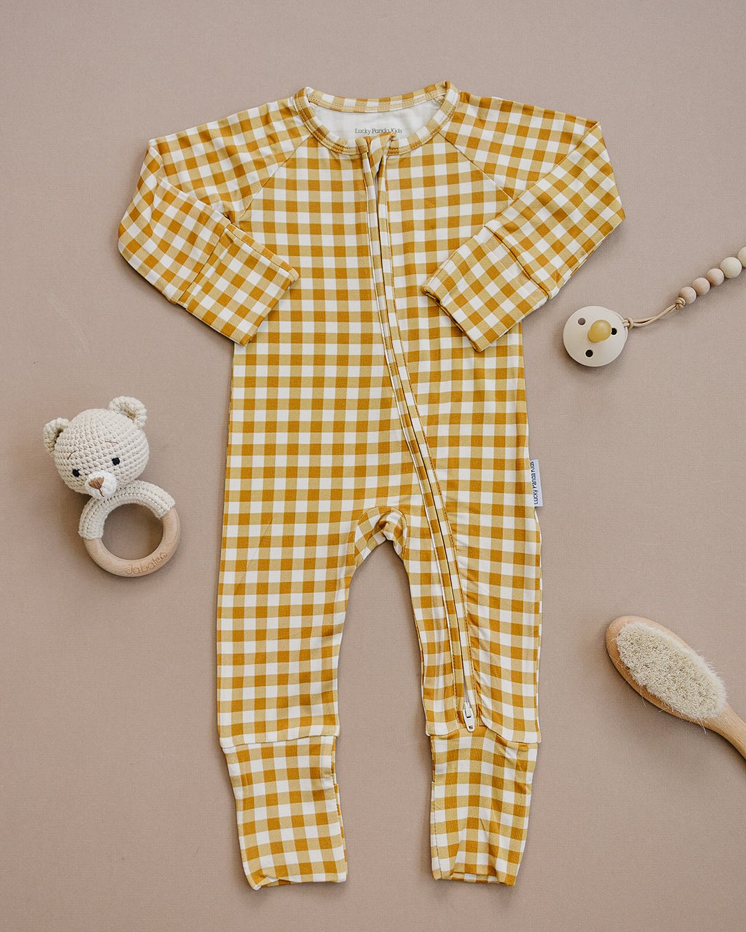 Close-up of the Yellow Gingham bamboo baby romper, showing the zipper and mustard-yellow checkered print.