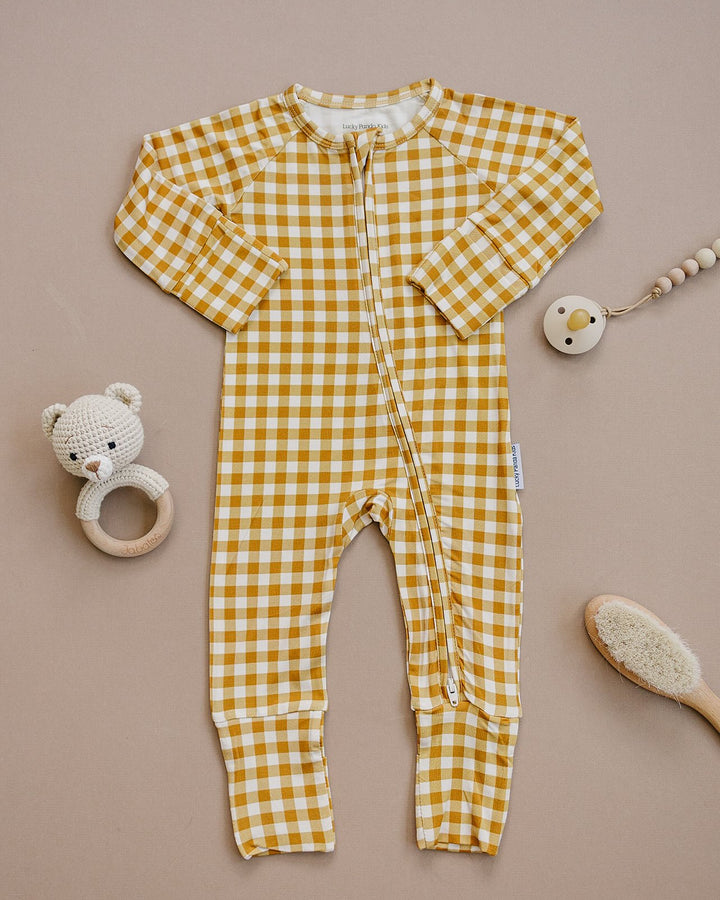 Close-up of the Yellow Gingham bamboo baby romper, showing the zipper and mustard-yellow checkered print.