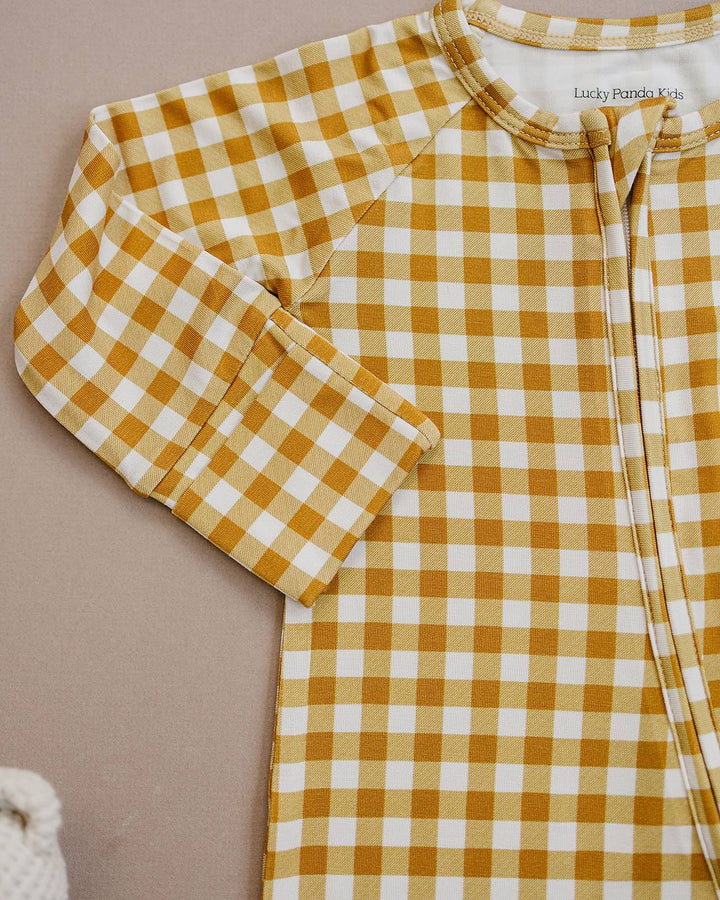 Close-up of the Yellow Gingham bamboo romper, showing the neckline, zipper, and checkered fabric.