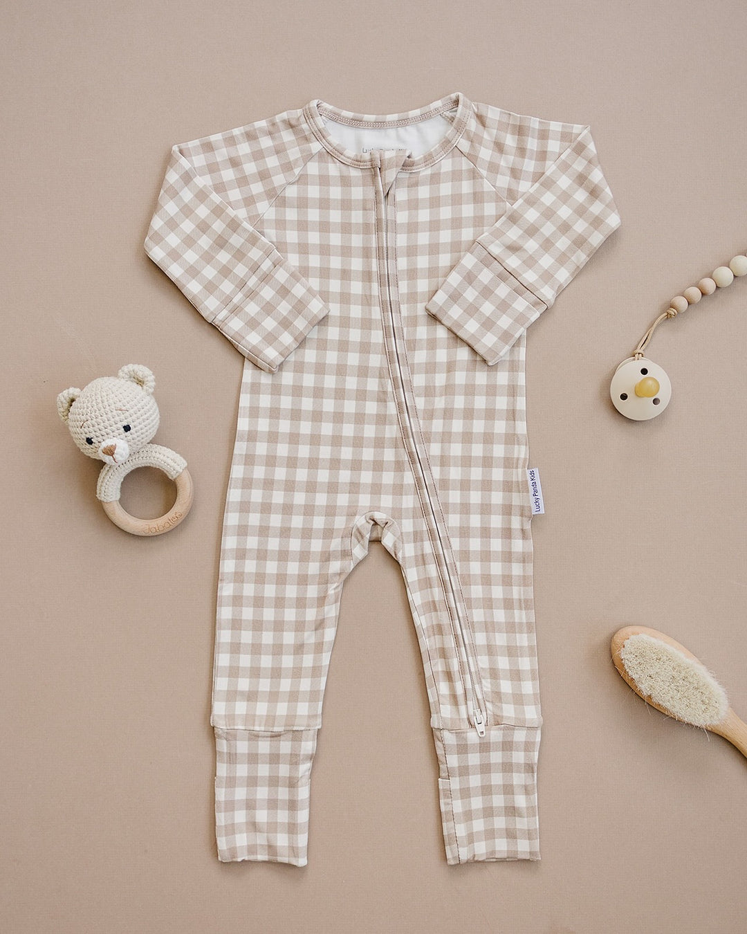 Lucky Panda Kids Beige Gingham bamboo zip romper displayed flat with neutral baby accessories.