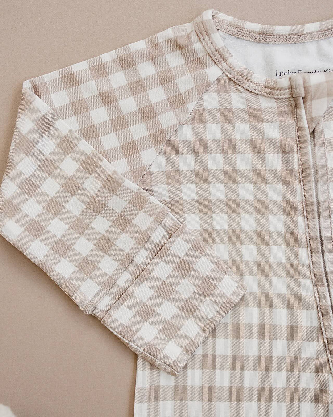 Close-up of the Beige Gingham bamboo romper, showing the neckline, zipper, and soft checkered fabric.