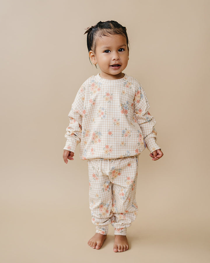 Child wearing Beige Gingham playing beside a baby in the Wild Flower cotton jogger set.