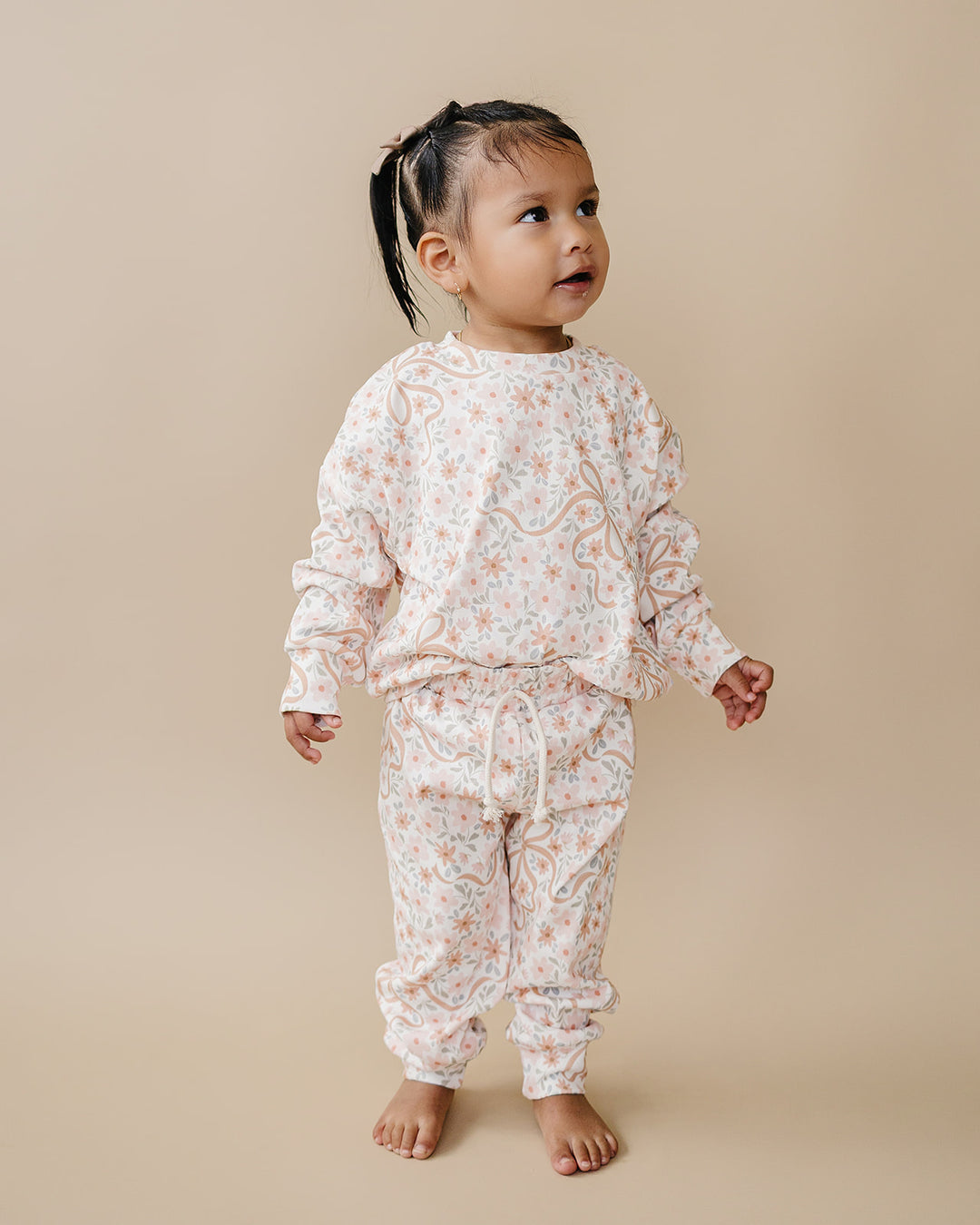 Toddler modeling the Cozy Daisy cotton jogger set in a full-length studio view.