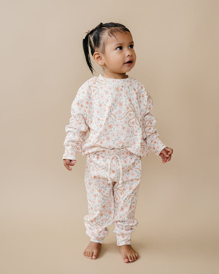 Toddler modeling the Cozy Daisy cotton jogger set in a full-length studio view.
