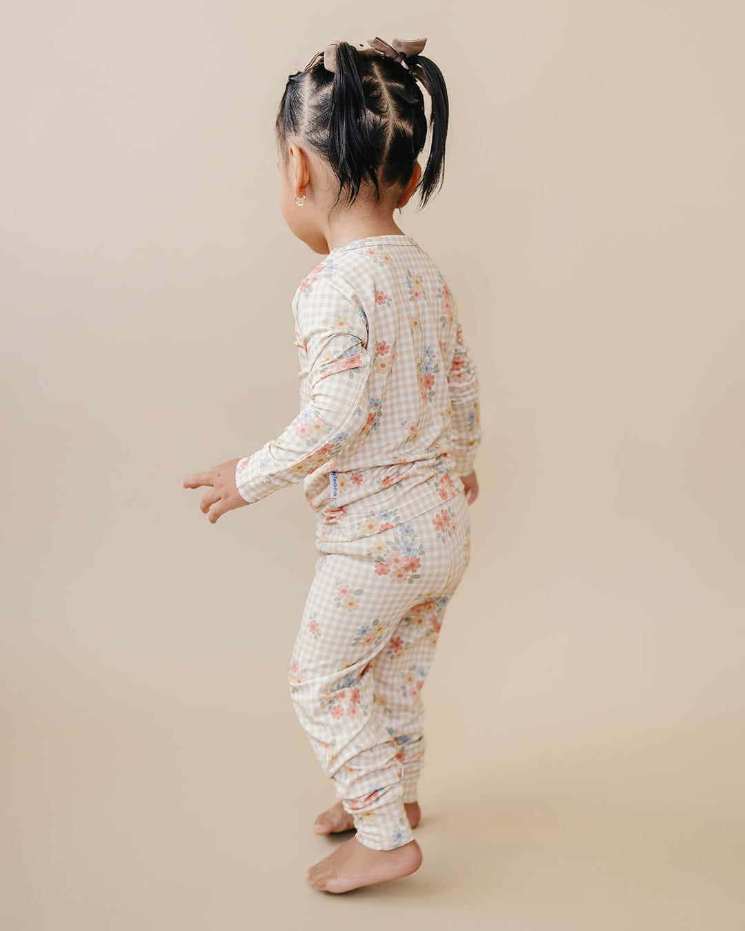 Side view of a toddler wearing the Wild Flower bamboo two-piece set against a neutral studio background.