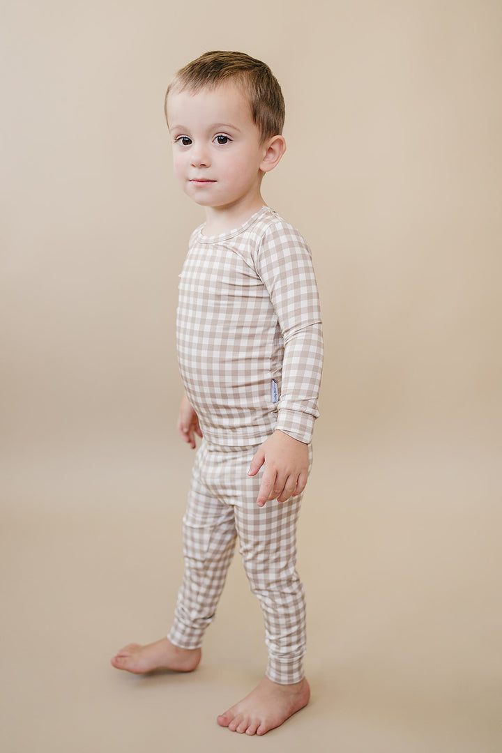 Side view of a toddler wearing the Beige Gingham bamboo two-piece set against a neutral background.