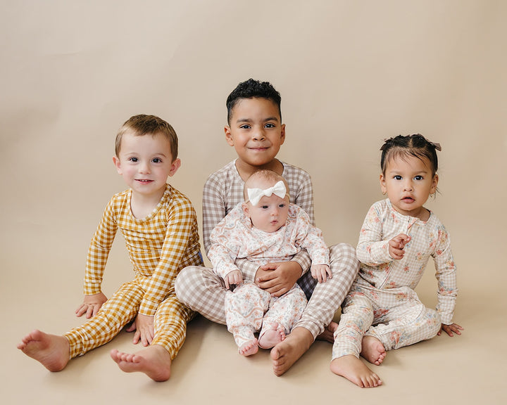 Children modeling coordinating Lucky Panda Kids gingham and floral bamboo styles in a group portrait.