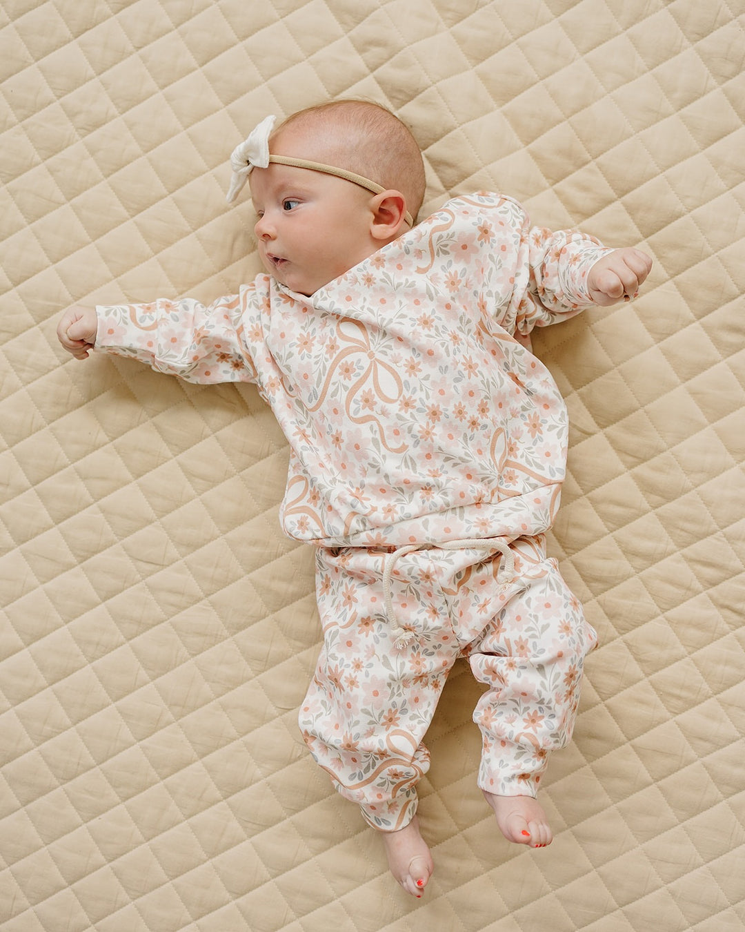 Full-body view of a baby wearing the Lucky Panda Kids Cozy Daisy cotton jogger set.
