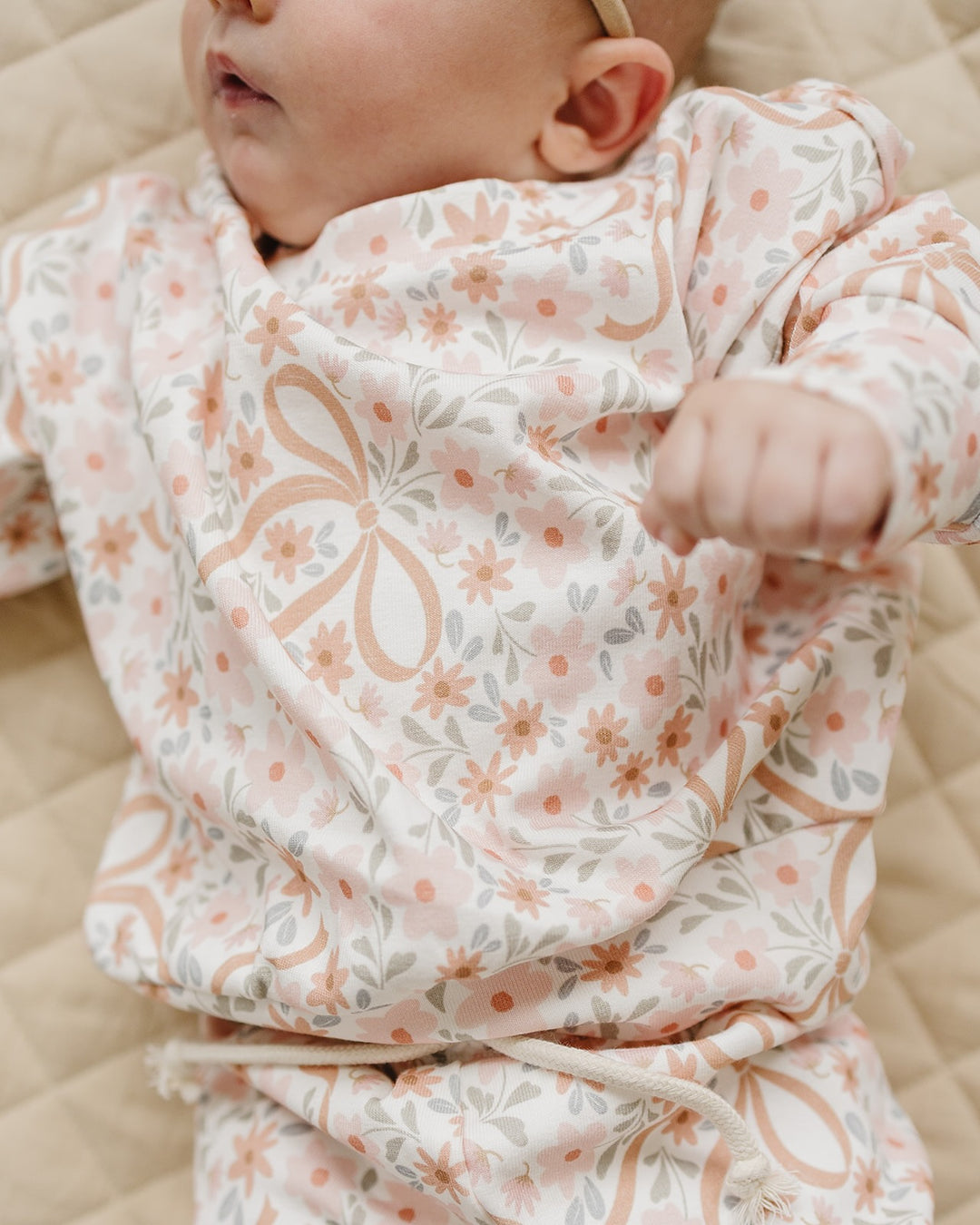 Close-up of a baby wearing the Lucky Panda Kids Cozy Daisy cotton sweatshirt.