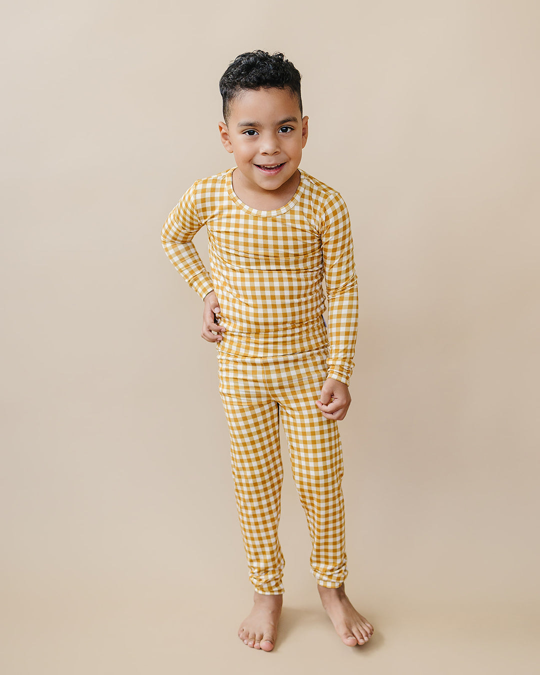 Smiling child modeling the Yellow Gingham bamboo pajama top and matching pants.