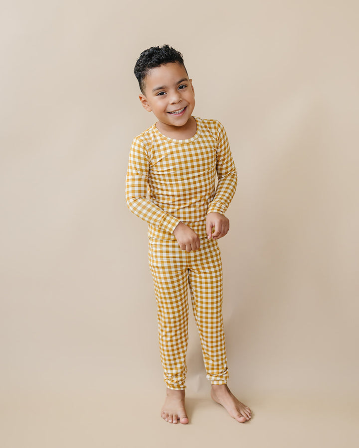 Full-body studio view of a child wearing the Lucky Panda Kids Yellow Gingham bamboo two-piece set.