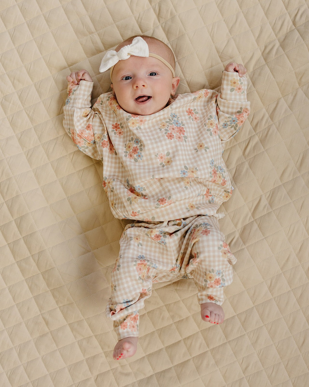 Full-body view of a baby wearing the Wild Flower cotton sweatshirt and matching jogger pants.