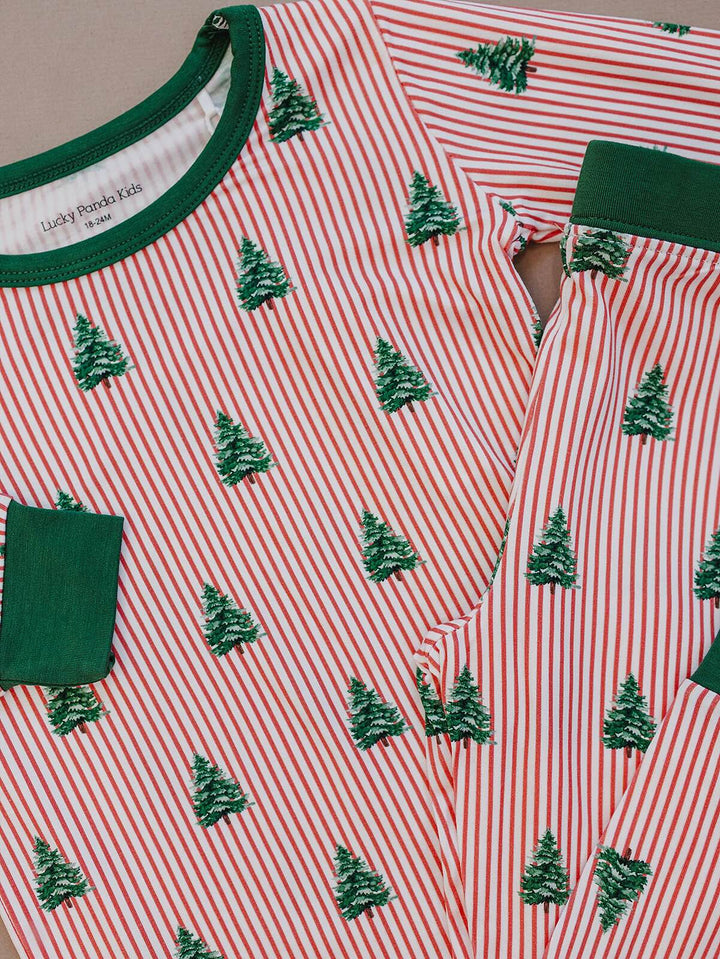 Detail of Magical Trees pajamas showing green Christmas trees on red and white stripes and green trim.