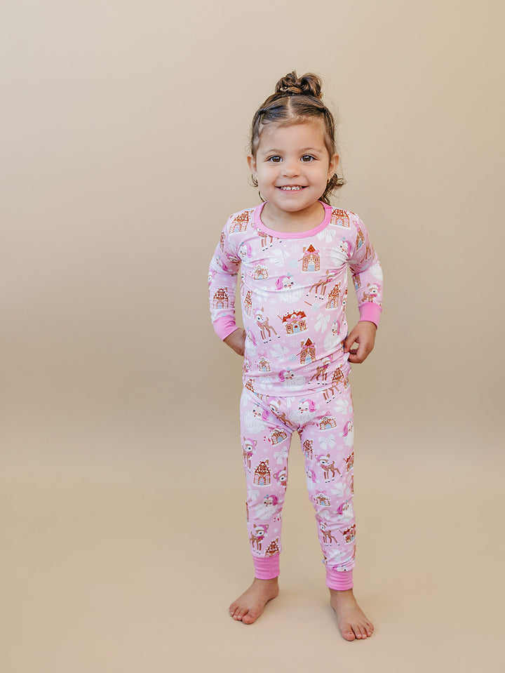 Toddler wearing Pink Christmas two piece pajamas with pink wrist and ankle cuffs.