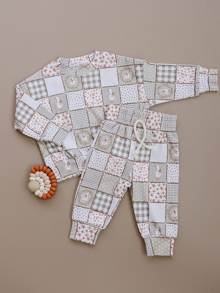 Cottage Goose long-sleeve top and matching jogger pants laid flat, showing the neutral patchwork goose print.