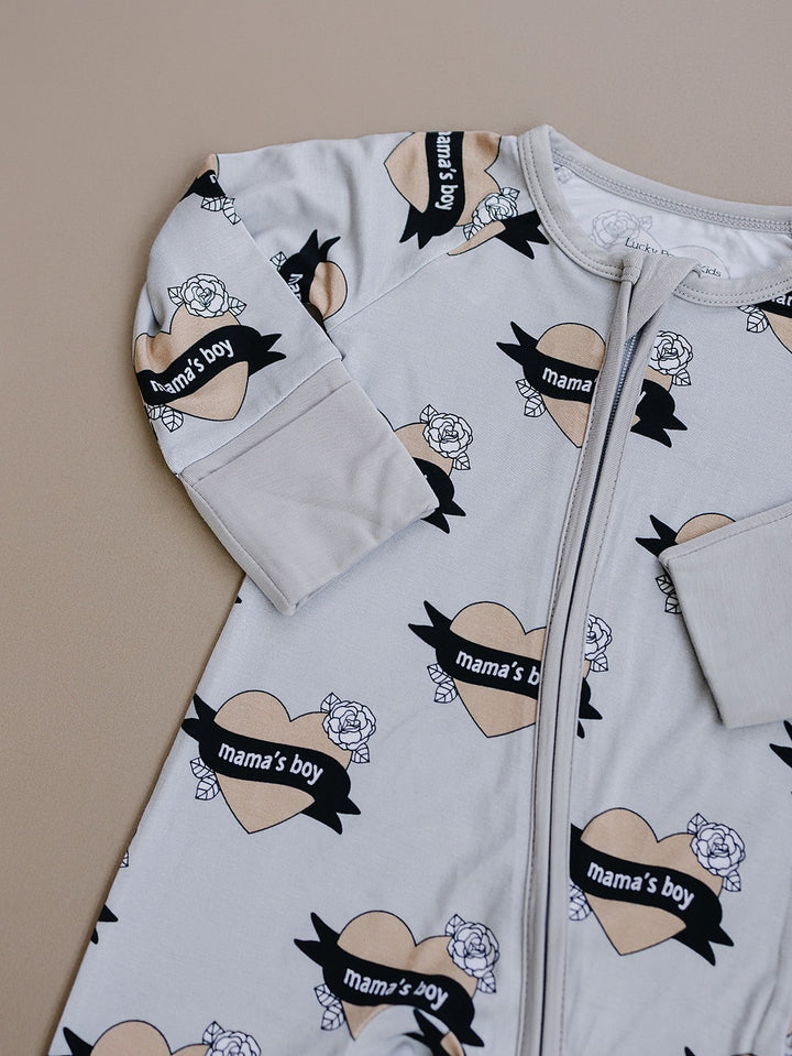 Flat-lay detail of the sleeve, zipper, and heart print on the Mama’s Boy bamboo romper.