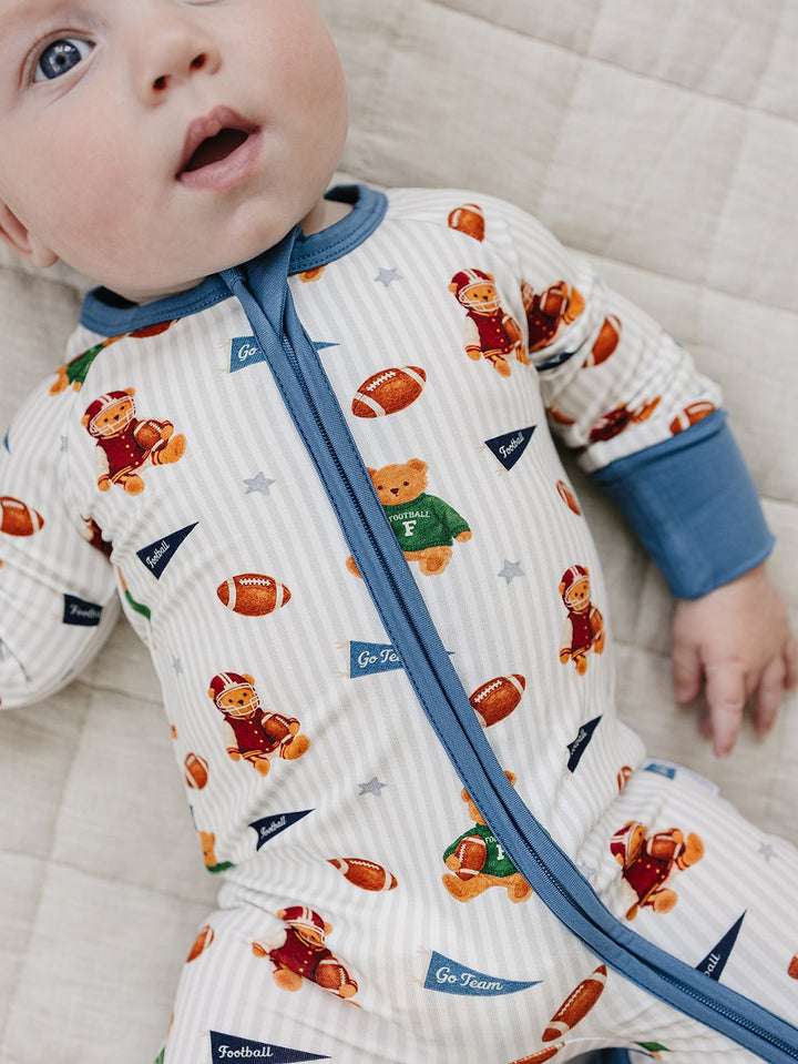Close-up of a baby wearing the Touchdown Teddy bamboo romper with football and teddy bear print.