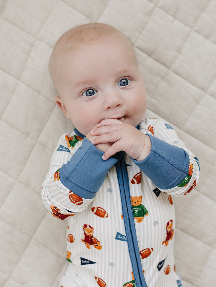 Close-up of a baby wearing the Touchdown Teddy bamboo romper with a two-way zipper.